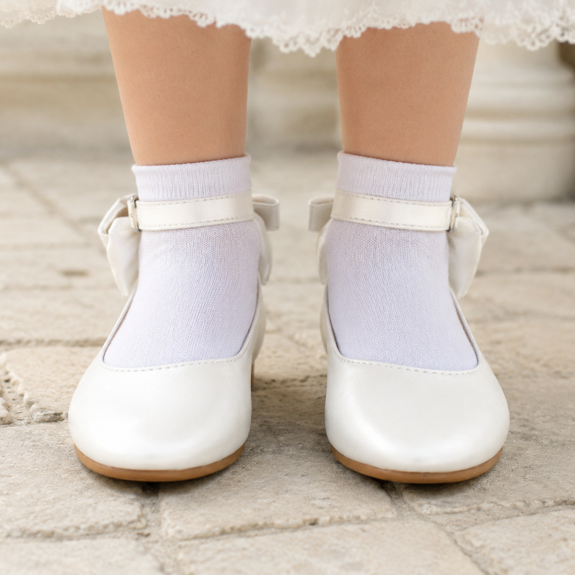 Vue de face de ballerines blanches de cérémonie pour fille à bout arrondi