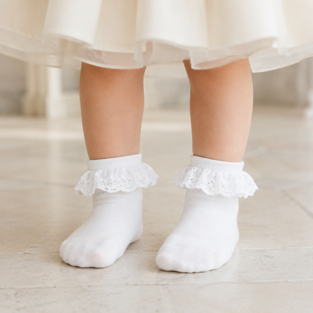 Petite fille de 2 ans portant des chaussettes blanches à volant en dentelle sans chaussures