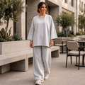 Femme portant un ensemble oversize gris clair avec haut ample et pantalon large