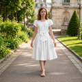 fille portant une robe de cérémonie écrue avec bustier brodé et détails perlés